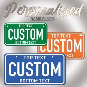 Puede incluir: Tres placas de identificaci&oacute;n rectangulares en verde, naranja y azul, cada una con texto blanco que dice TOP TEXT, CUSTOM y BOTTOM TEXT. En la parte superior de la imagen aparecen las palabras PERSONALIZED NAME PLATES en letra cursiva.