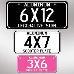 Puede incluir: Tres letreros rectangulares de aluminio con esquinas redondeadas. El letrero superior es negro con texto blanco que dice ALUMINUM 6X12 DECORATIVE SIGN. El letrero central es blanco con texto negro ALUMINUM 4X7 SCOOTER PLATE. El letrero inferior es rosa con texto blanco ALUMINUM 3X6 BICYCLE PLATE.