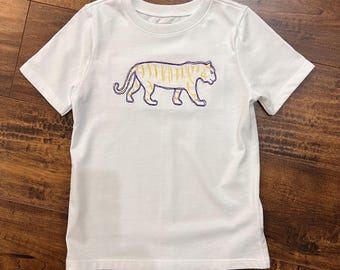 May include: White short-sleeved t-shirt with a purple and gold embroidered tiger design.
