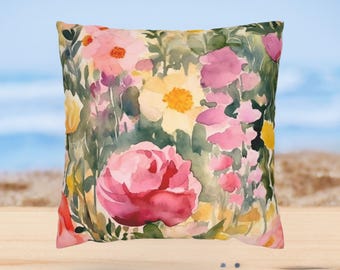 May include: A watercolor floral pillow cover featuring a variety of pink, yellow, and green flowers. The pillow cover is perfect for adding a touch of nature to any room.