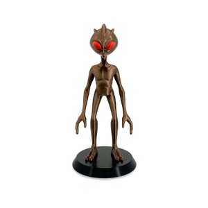 Varginha Alien Figurine, Detailed Brazilian UFO Encounter Creature, Copper Brown Metallic Body, Red Eyes, Black Base