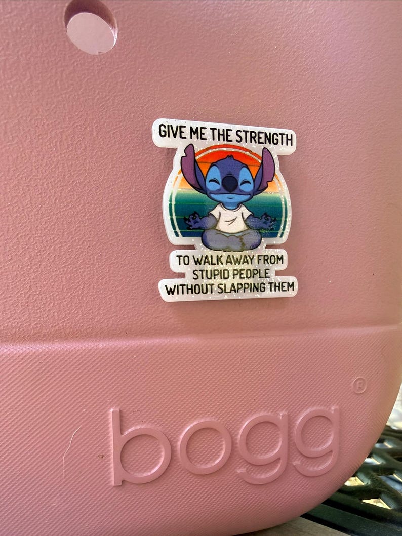 K&ouml;nnte beinhalten: Rosa Tragetasche mit dem Wort "bogg" auf der Vorderseite. Ein wei&szlig;er Aufkleber mit der Figur Stitch aus Lilo & Stitch ist auf der Tasche angebracht. Der Aufkleber lautet: "GIVE ME THE STRENGTH TO WALK AWAY FROM STUPID PEOPLE WITHOUT SLAPPING THEM."