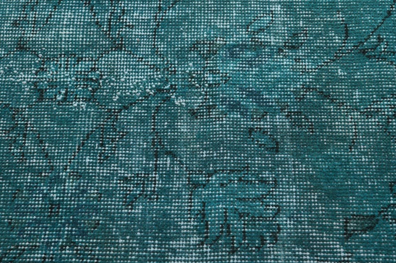 May include: Teal blue rug with a woven pattern of white and black lines. The rug has a distressed look, giving it a vintage feel.