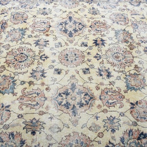 May include: A vintage rug with a cream background and intricate floral patterns in shades of blue, red, and green.