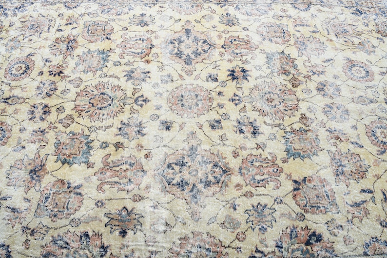 May include: A vintage rug with a cream background and intricate floral patterns in shades of blue, red, and green.