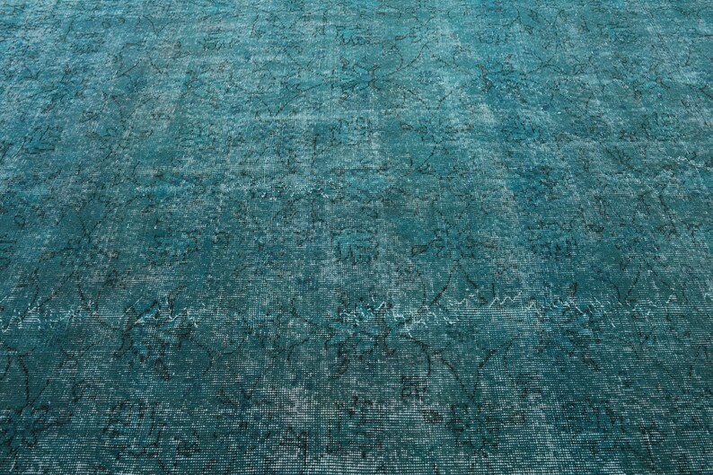 May include: A teal blue rug with a faded, distressed pattern. The rug has a vintage look and feel.