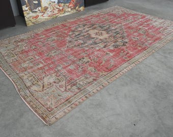 May include: A vintage red and cream rug with a floral pattern. The rug has a faded, distressed look and is made of a soft, woven material.