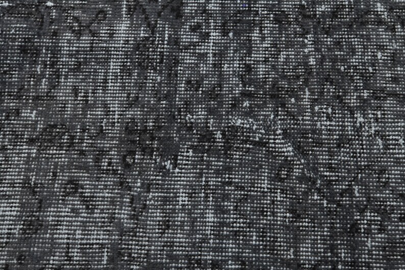 May include: A close-up of a black and white patterned rug with a textured surface.