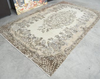Könnte beinhalten: Ein vintage cremefarbener Teppich mit braunem Blumenmuster. Der Teppich hat einen abgenutzten Look und ist perfekt, um jedem Raum einen Hauch von Vintage-Charme zu verleihen.