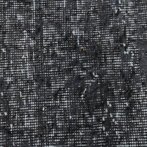 May include: Close-up of a black and white textured fabric with a subtle pattern. The fabric has a woven appearance and a slightly rough texture.