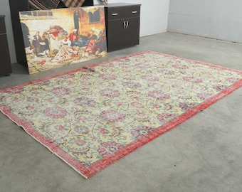 May include: A rectangular area rug featuring a cream-colored field with an all-over floral pattern in shades of pink, blue, and green. The rug is framed by a wide, solid red border that runs along all four edges, creating a distinct contrast.