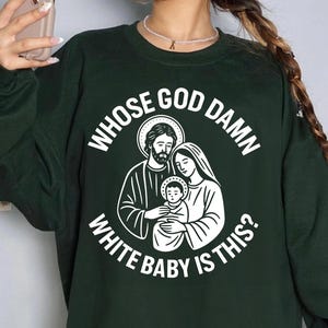 May include: Dark green sweatshirt with a white graphic of a religious family and the text "WHOSE GOD DAMN WHITE BABY IS THIS?"