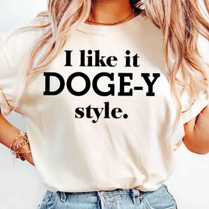 May include: White t-shirt with black text that reads "I like it DOGE-Y style."