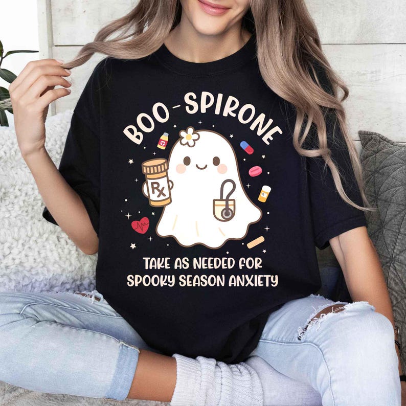 May include: Black t-shirt with the text "BOO-SPIRONE" and a cute ghost graphic holding a prescription bottle and stethoscope. The shirt also says "TAKE AS NEEDED FOR SPOOKY SEASON ANXIETY".