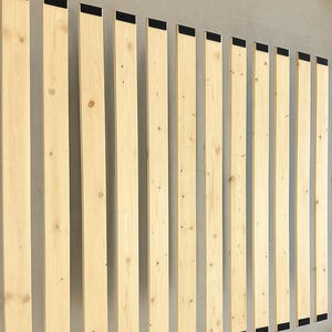 May include: A set of light-colored wooden bed slats with black fabric strips at the top. The slats are arranged vertically against a neutral-colored wall, showcasing the natural wood grain and knots.