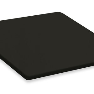 May include: A black square-shaped cutting board made of a textured material.