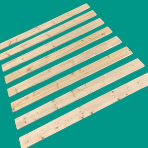 May include: Nine wooden slats, all the same size and color, are arranged in a fan shape. The slats are light brown and have a smooth, natural finish.