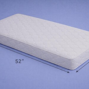 May include: A white rectangular mattress with a quilted surface. The mattress is 52 inches long and 28 inches wide. The mattress is on a blue background.