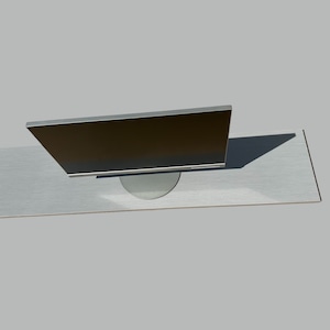 May include: A silver computer monitor with a black screen is sitting on a silver table.