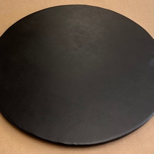 May include: A black round tray with two clear crystal knobs on the sides.