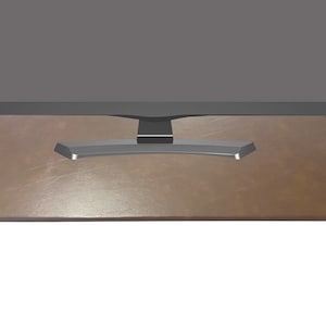 May include: A brown leather monitor stand with a black monitor on top. The stand is designed to raise the monitor to a more ergonomic height.