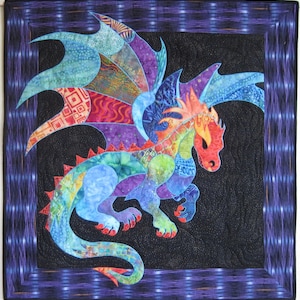 May include: A colorful dragon quilt with a black background and a patterned border. The dragon features shades of red, orange, blue, green, and purple. The wings are large and detailed, and the dragon is in a dynamic pose.