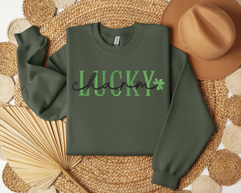 May include: A green sweatshirt with the text "LUCKY charm" in black and green lettering with a shamrock graphic.