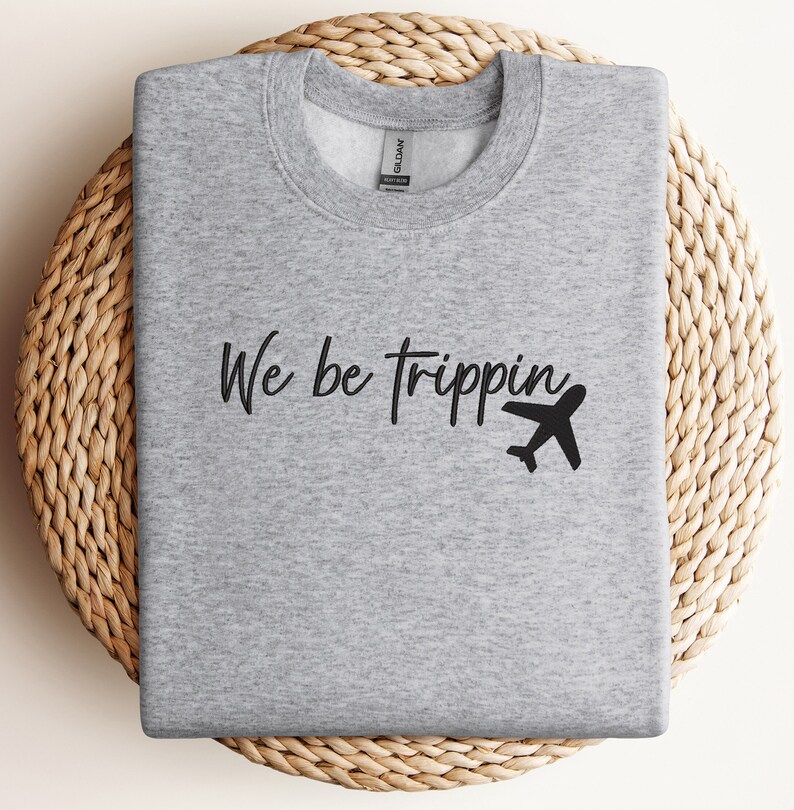 May include: Gray sweatshirt with the text "We be trippin'" and a black airplane graphic.