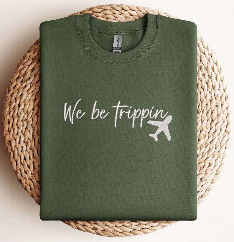 May include: A green sweatshirt with the text "We be trippin'" in white lettering and a white airplane graphic.