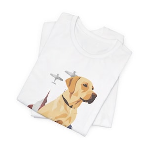 Op de afbeelding: Wit T-shirt met een gele Labrador Retriever hond en drie vliegtuigen op de achtergrond. De hond kijkt naar rechts. De vliegtuigen vliegen in formatie.
