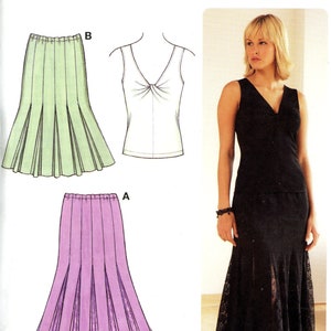 May include: Sewing pattern for a skirt with two different styles. The first style is a green skirt with pleats. The second style is a black skirt with lace trim. The pattern is called "Kwik Sew" and the number is 3549.