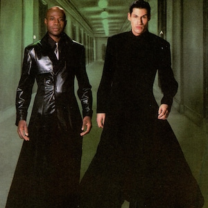 May include: A Simplicity 5386 sewing pattern envelope for adult costumes featuring two long black coats. One coat is a shiny, textured black material, and the other is a matte black fabric. The text reads Simplicity Costumes for adults.