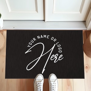 May include: Black doormat with white text that says "Your name or logo here" in a circle.