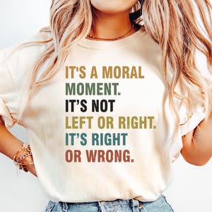 May include: A white t-shirt with a retro-style graphic that reads "It's a moral moment. It's not left or right. It's right or wrong."