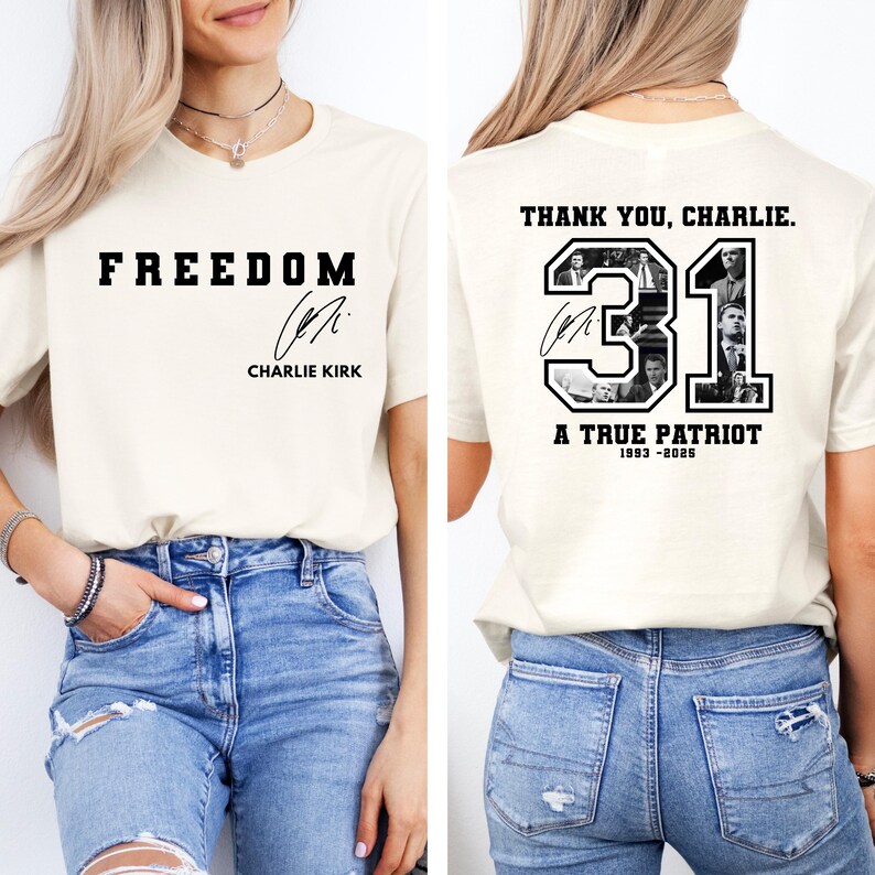 May include: Cream-colored t-shirt with the word "FREEDOM" in bold black letters on the front, along with a signature and the name "CHARLIE KIRK." The back of the shirt features the text "THANK YOU, CHARLIE," the number "31," and the words "A TRUE PATRIOT 1993-2020."