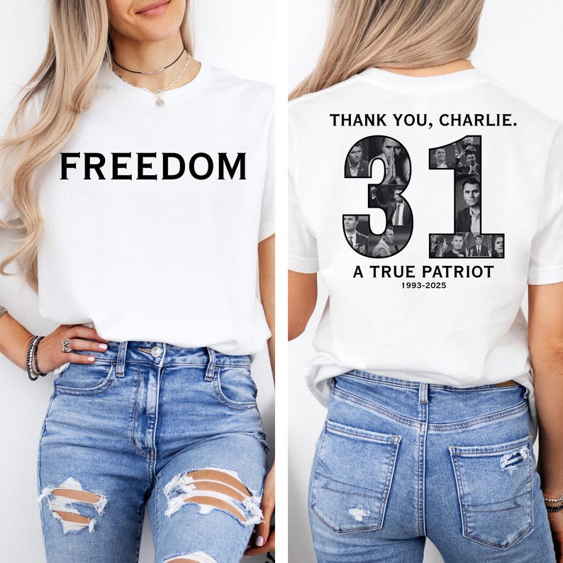 K&ouml;nnte beinhalten: Wei&szlig;es T-Shirt mit dem Wort "FREEDOM" in Schwarz auf der Vorderseite. Auf der R&uuml;ckseite des Shirts steht der Text "THANK YOU, CHARLIE." mit der Zahl "31" und den Worten "A TRUE PATRIOT" und den Jahren "1993-2025".