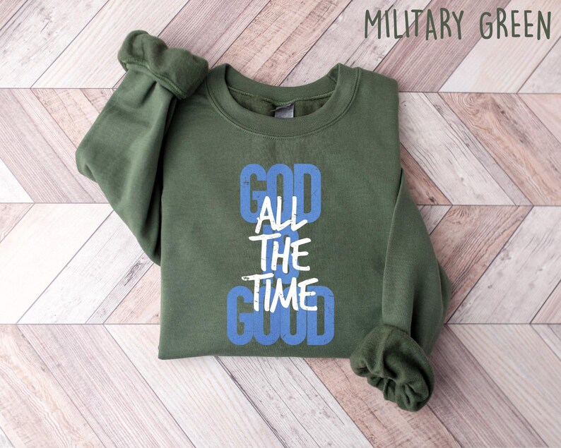May include: A green sweatshirt with the text "God All The Time Good" in white and blue lettering.