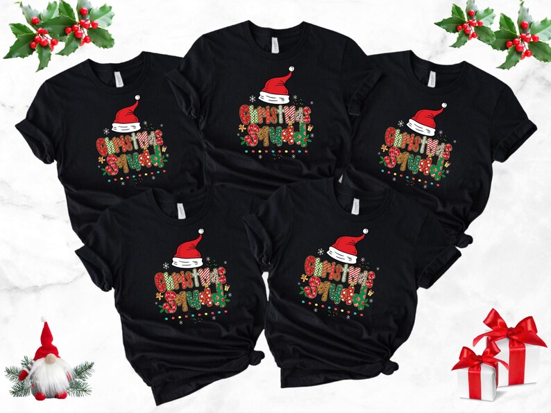 May include: Black t-shirts with a festive "Christmas Squad" design. Each shirt features a Santa hat and colorful text. The shirts are arranged on a white surface, with holiday decorations.