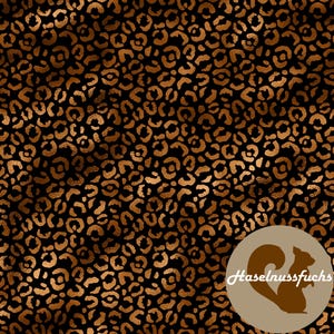 Op de afbeelding: Een naadloos luipaardprintontwerp in bruin en goud op een zwarte achtergrond. Het patroon bestaat uit talrijke onregelmatige, afgeronde vormen. Een cirkelvormig logo met een eekhoornsilhouet en de tekst "Haselnussfuchs" staat rechtsonder.