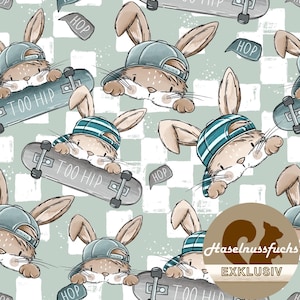 Könnte beinhalten: Ein sich wiederholendes Muster mit Cartoon-Hasen, die Mützen tragen und Skateboard fahren. Die Hasen sind hellbraun mit blauen Mützen und Skateboards. Auf den Skateboards steht der Text "TOO HIP". Der Hintergrund ist hellgrün mit einem Schachbrettmuster.