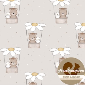 Op de afbeelding: Een herhalend patroon met cartoonberen en kuikens in madeliefvormige luchtballonnen. De ballonnen zijn wit met gele centra, tegen een lichtbeige achtergrond met kleine witte stippen. De afbeelding heeft een grillig, speels gevoel.