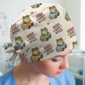 May include: A white ceramic mug with a black handle and the text "But First, Coffee" in a black, handwritten-style font. The mug is on a white surface.