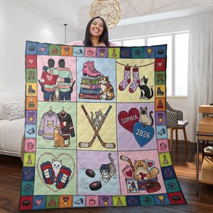 Puede incluir: Una colorida colcha con ilustraciones temáticas de hockey y gatos. La colcha incluye imágenes de jugadores de hockey, patines, palos de hockey, gatos y el texto "HOCKEY ROMANCE" y "SOPHIA 2026".