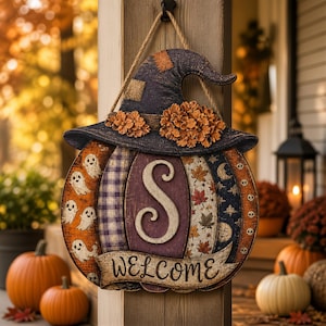 Peut inclure: Une décoration murale en forme de citrouille avec un chapeau de sorcière violet foncé et des fleurs orange. La citrouille présente des panneaux verticaux à motifs de fantômes, carreaux, feuilles et crânes, une lettre S et le mot WELCOME.