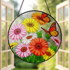 May include: Round stained glass window hanging featuring a colorful floral design with pink, yellow, orange, and white gerbera daisies and two monarch butterflies.