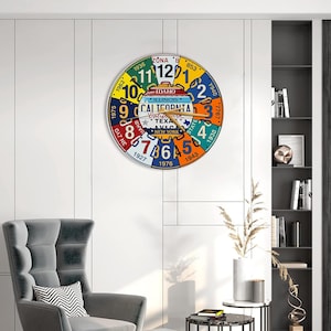 May include: A round wall clock with a colorful design featuring license plates from various states. The clock face displays numbers and the names of states like California and New York. The clock hands are brown.