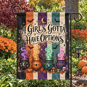 Peut inclure: Un drapeau de jardin rectangulaire avec des rayures verticales noires, orange, violettes et bleu sarcelle. Le texte A Girl's Gotta Have Options est centré au-dessus de quatre chaudrons colorés dégageant de la fumée violette, jaune, verte et rose.