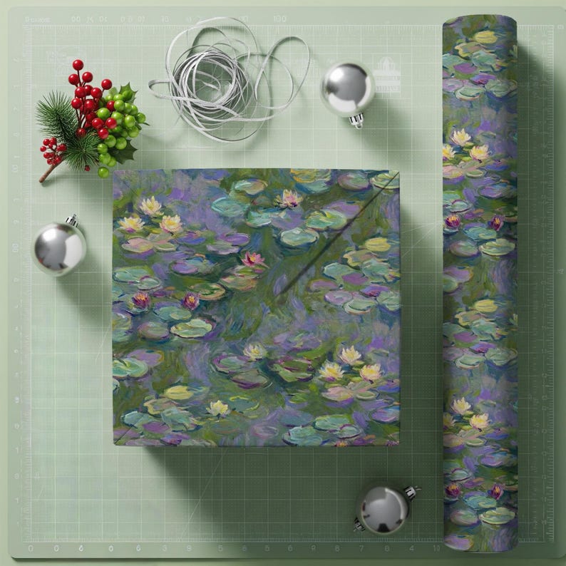 May include: Gift wrap featuring a water lily design in shades of purple, green, and yellow. A wrapped box and a roll of the same paper are displayed with silver ornaments, ribbon, and a sprig of berries.