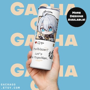 May include: A white tumbler featuring a cartoon character design with blue eyes and silver hair. The tumbler has the text "Trailblazer! Let's Go Together." and "More Designs Available!" on a light blue background.