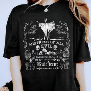 May include: Black t-shirt with a white graphic design featuring Maleficent from Sleeping Beauty. The design includes the text "Mistress of All Evil", "Sleeping Beauty", "19", "59", and "Maleficent".